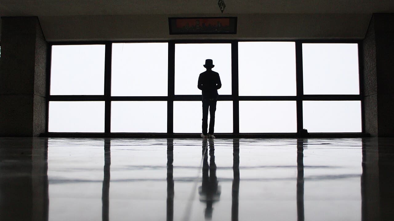 A silhouetted figure at a high window overlooking Johannesburg